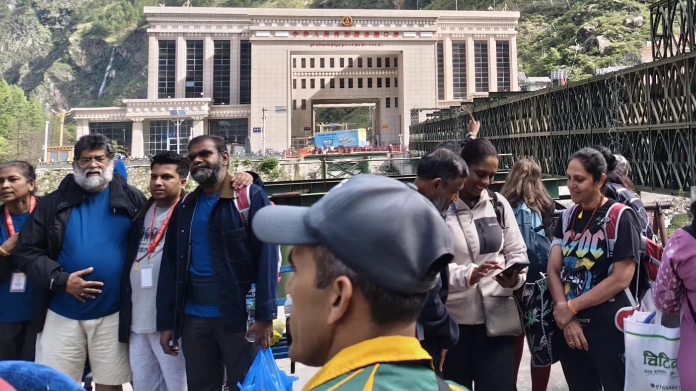 Pilgrims stand in front of the Gyirong Port Immigration Building and the Nepal-China Friendship Bridge last month, both of which were washed away in a flash flood last week. (Supplied photo)